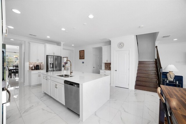 kitchen featuring sink, appliances with stainless steel finishes, white cabinets, and decorative backsplash