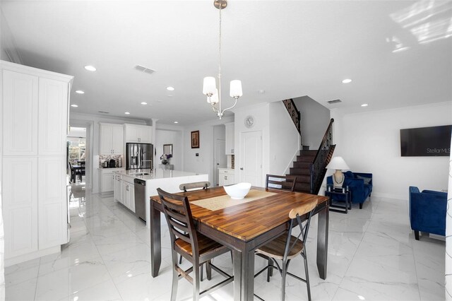 dining space featuring crown molding and an inviting chandelier