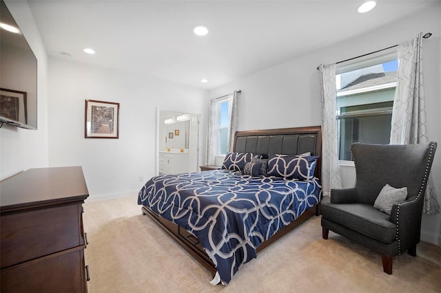 bedroom with connected bathroom and light colored carpet