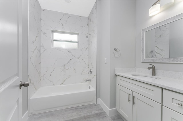 bathroom featuring tiled shower / bath combo and vanity