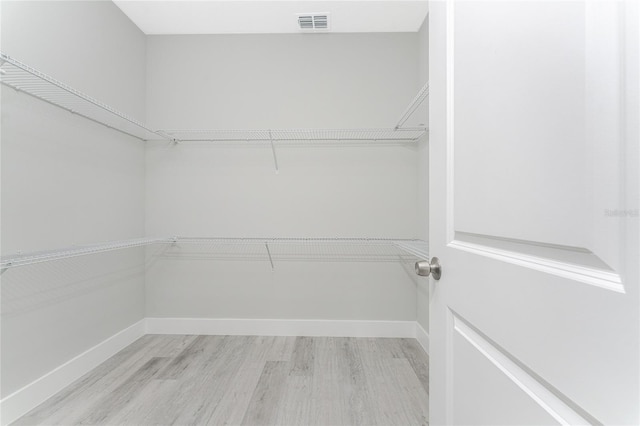 spacious closet featuring light hardwood / wood-style floors