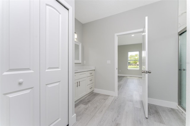 bathroom with hardwood / wood-style flooring, a shower with shower door, and vanity