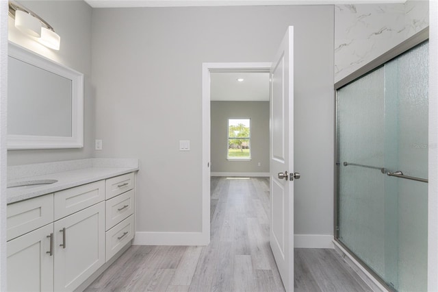 bathroom with an enclosed shower, vanity, and hardwood / wood-style floors