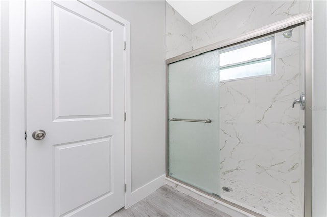 bathroom with hardwood / wood-style flooring and a shower with door