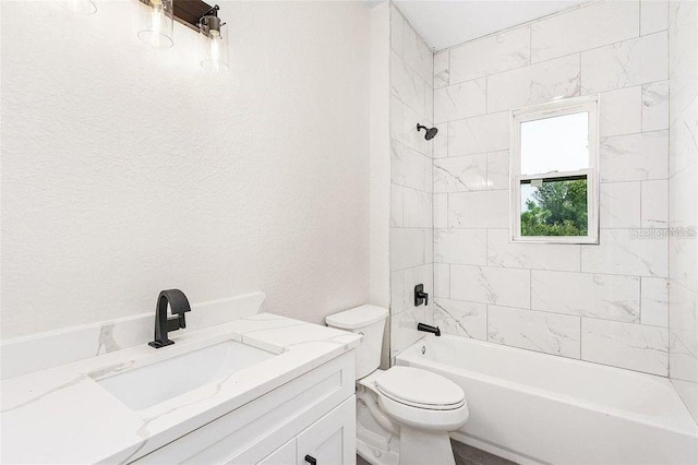 full bathroom featuring tiled shower / bath, vanity, and toilet