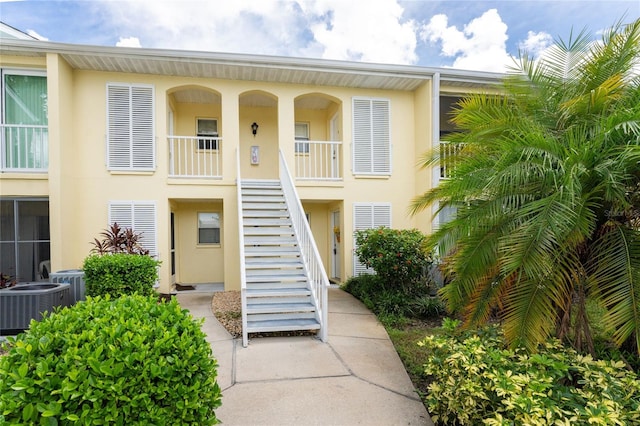 view of front of property featuring cooling unit and a balcony