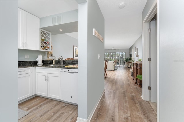 interior space with light wood finished floors, visible vents, baseboards, and a sink