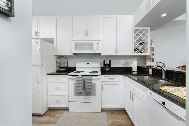 kitchen featuring a sink, white appliances, and white cabinetry