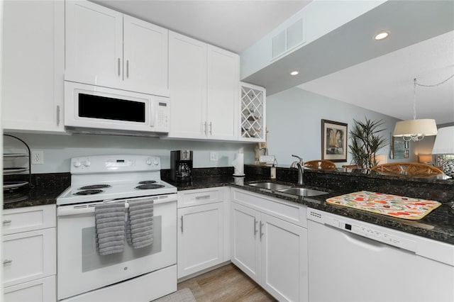 kitchen featuring a sink, visible vents, white appliances, and white cabinetry