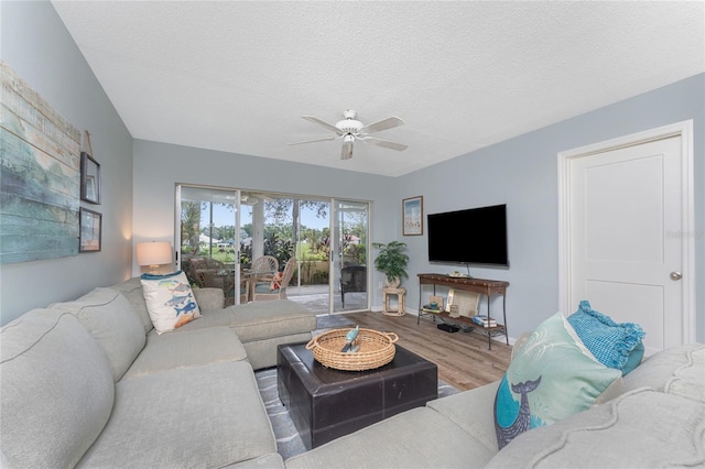 living room featuring wood finished floors, a textured ceiling, and ceiling fan