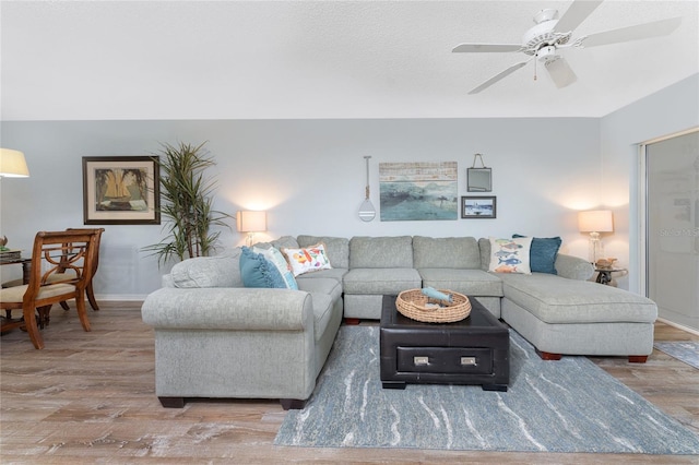 living room with baseboards, a ceiling fan, and wood finished floors