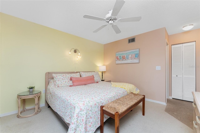 bedroom featuring visible vents, baseboards, light colored carpet, a closet, and a ceiling fan