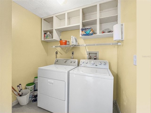 laundry room with baseboards, a textured ceiling, laundry area, and washing machine and clothes dryer