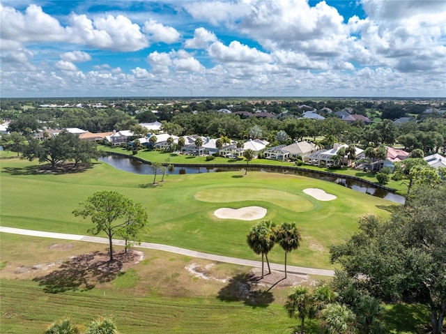 birds eye view of property with golf course view and a water view