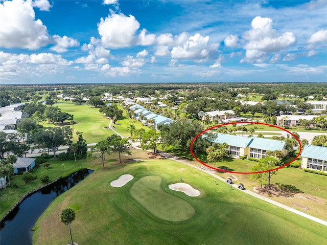 aerial view with golf course view and a water view