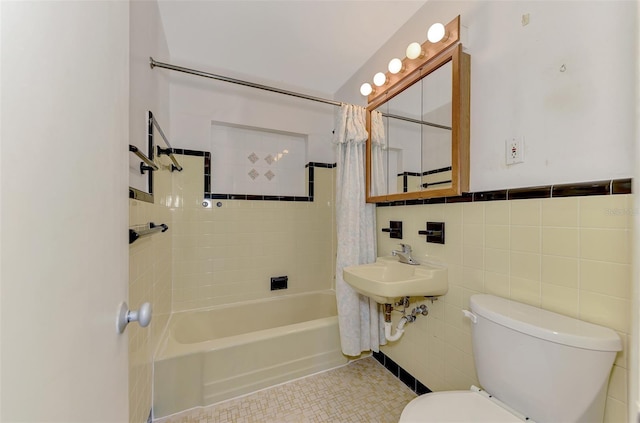 full bathroom featuring sink, tile walls, tile patterned flooring, toilet, and shower / bath combo with shower curtain