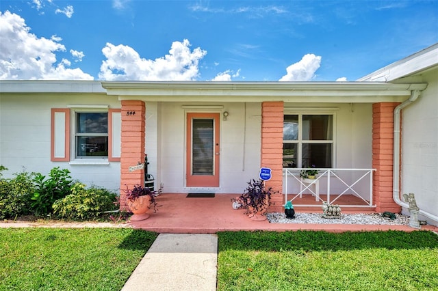 property entrance featuring a porch and a lawn