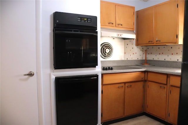 kitchen featuring decorative backsplash, black appliances, and light wood-type flooring