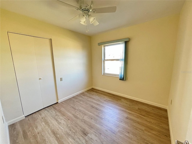 unfurnished bedroom with ceiling fan, a closet, and light hardwood / wood-style flooring