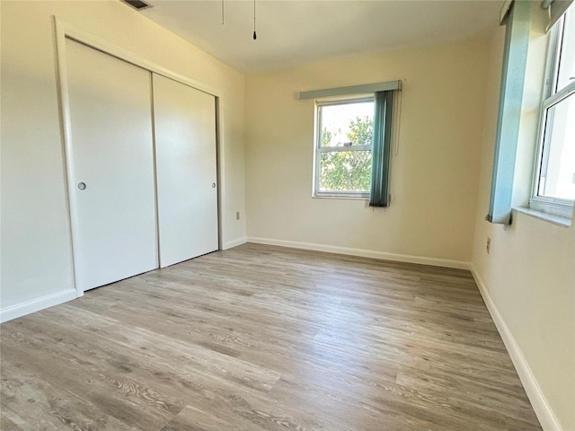 unfurnished bedroom featuring light hardwood / wood-style floors and a closet