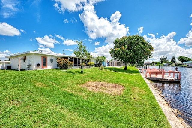 view of yard featuring a water view and a dock