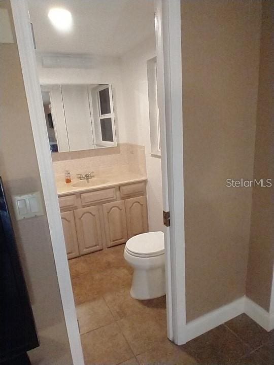 bathroom featuring vanity, toilet, and tile patterned floors