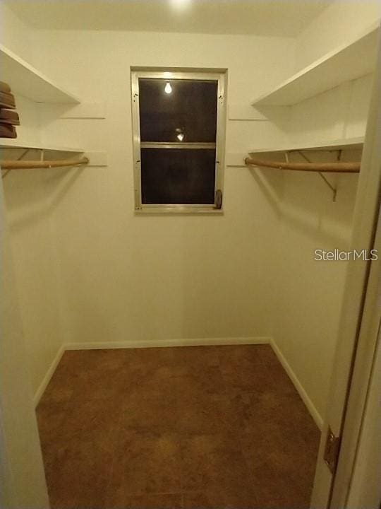 spacious closet with dark carpet