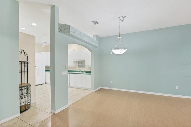 tiled empty room featuring sink and ceiling fan