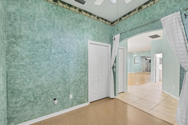 empty room with light tile patterned flooring and ceiling fan