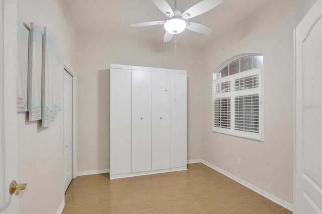 unfurnished bedroom with ceiling fan, a closet, and light hardwood / wood-style floors