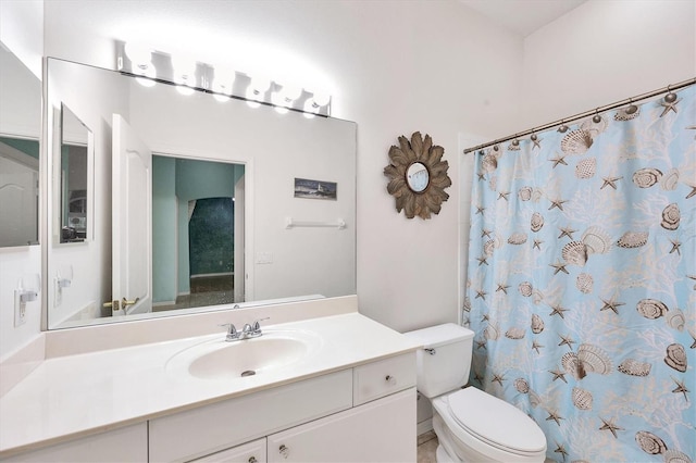 bathroom featuring curtained shower, vanity, and toilet