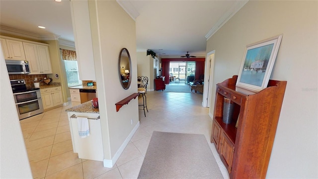 corridor featuring light tile patterned floors, baseboards, ornamental molding, and recessed lighting