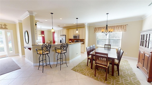 dining space with light tile patterned floors, a healthy amount of sunlight, and crown molding