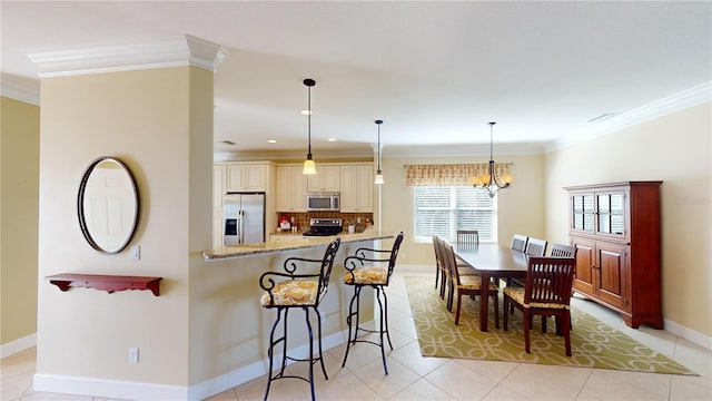 kitchen with ornamental molding, appliances with stainless steel finishes, light stone counters, and decorative backsplash