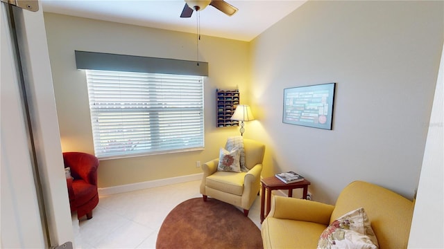 living area featuring baseboards and a ceiling fan