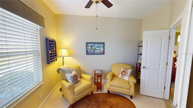 sitting room with a ceiling fan, tile patterned flooring, and baseboards