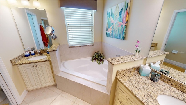 bathroom with a garden tub, tile patterned flooring, two vanities, and a sink