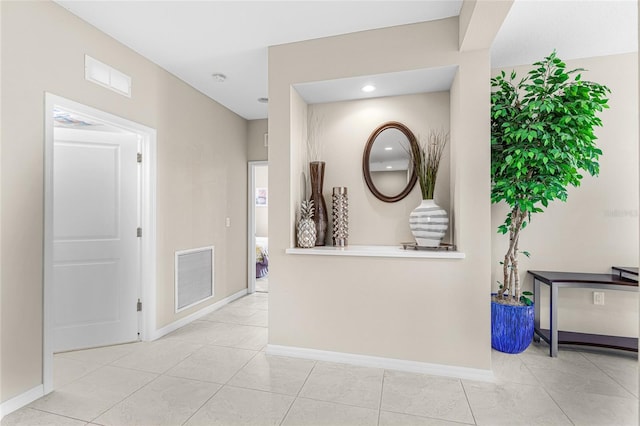 hall with light tile patterned floors