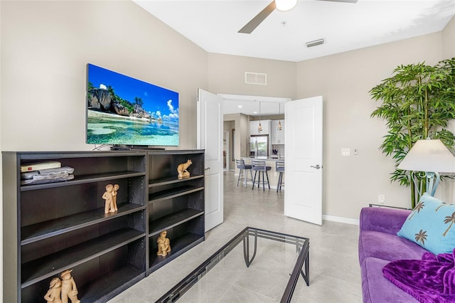 living room with ceiling fan and light tile patterned flooring