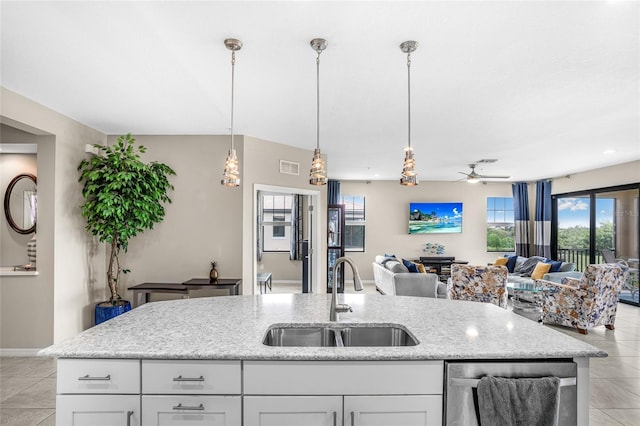 kitchen featuring sink, dishwasher, white cabinetry, and light tile patterned floors