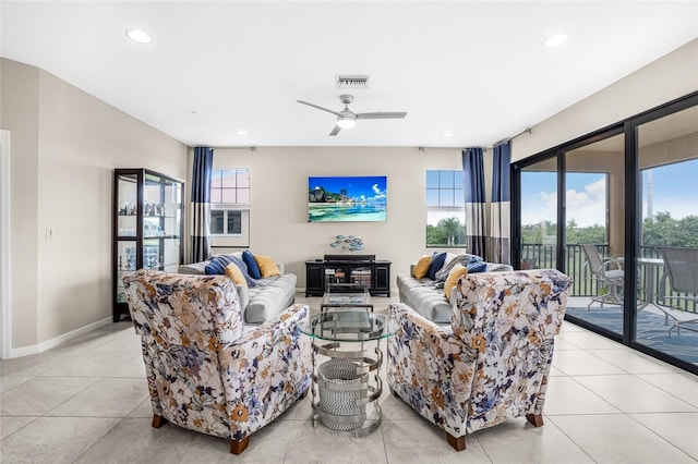 tiled living room with a wealth of natural light and ceiling fan