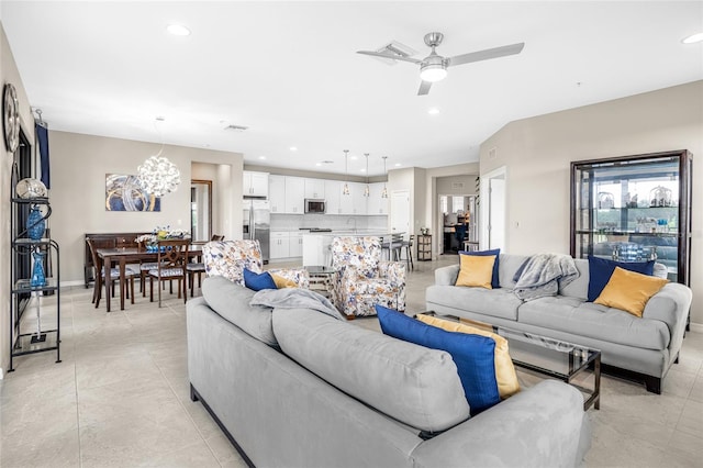 living room featuring ceiling fan with notable chandelier and light tile patterned floors