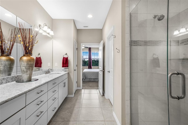 bathroom featuring a shower with shower door, tile patterned flooring, and vanity