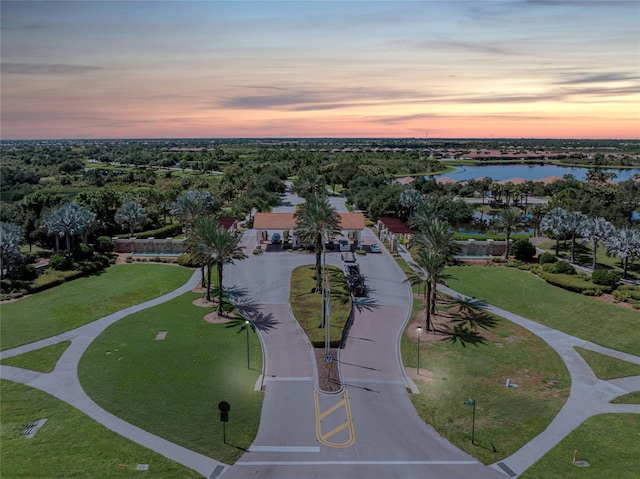 aerial view at dusk featuring a water view