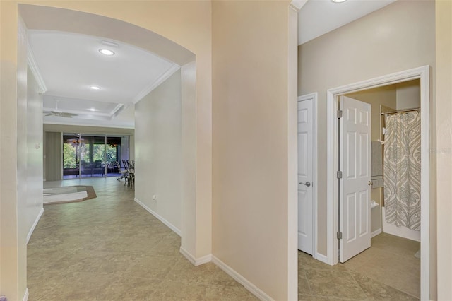 hallway featuring arched walkways, ornamental molding, recessed lighting, and baseboards