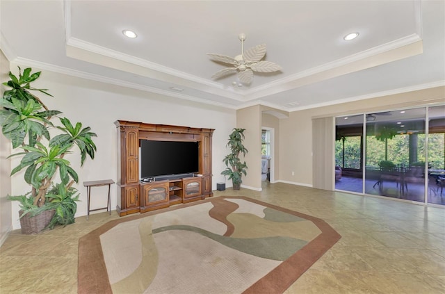 tiled living room with a raised ceiling, ceiling fan, and ornamental molding