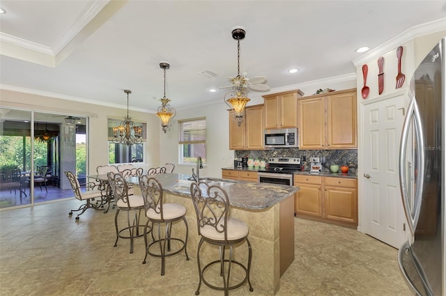 kitchen with ornamental molding, stainless steel appliances, a wealth of natural light, and a center island with sink