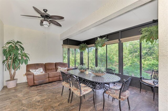 sunroom featuring beamed ceiling and ceiling fan