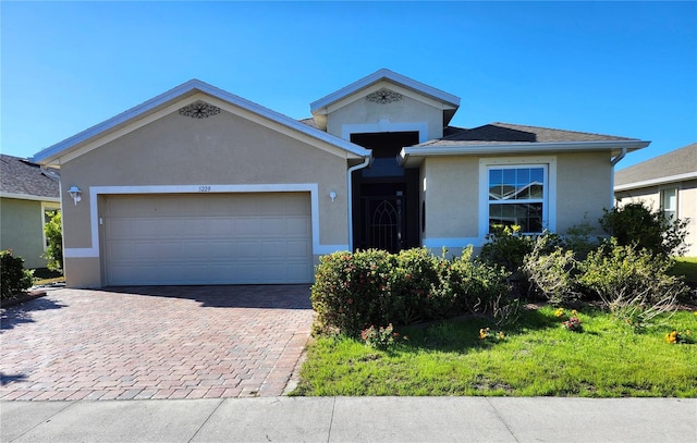 ranch-style house with decorative driveway, an attached garage, and stucco siding