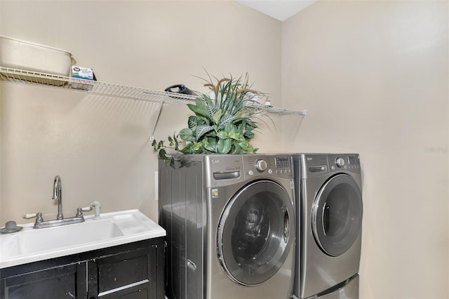 laundry area featuring cabinets, washing machine and dryer, and sink